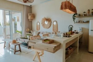 Boho-style open kitchen and living space with natural wooden furniture, earthy tones, and decorative mirrors on the wall.It shows modern interior colour trends 2026